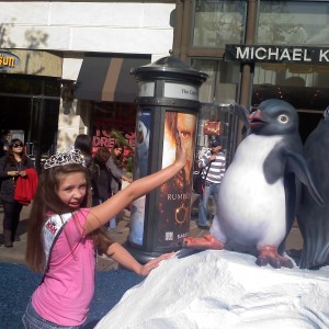 Paige Romero High Fiving with Happy Feet Penguins at The Grove